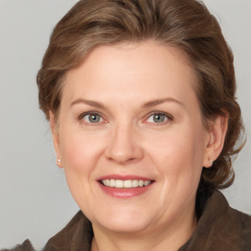 Joyful white adult female with medium  brown hair and grey eyes