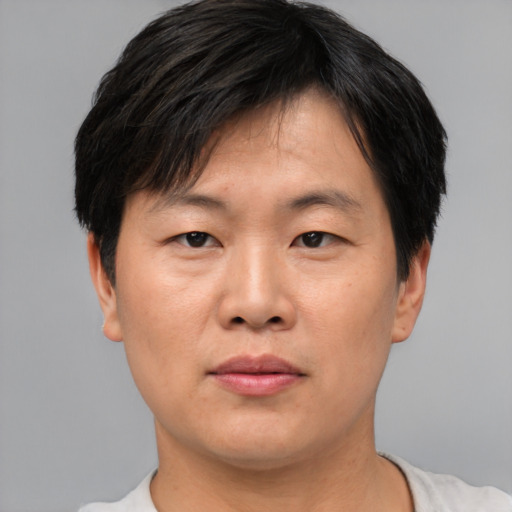 Neutral asian adult male with short  brown hair and brown eyes