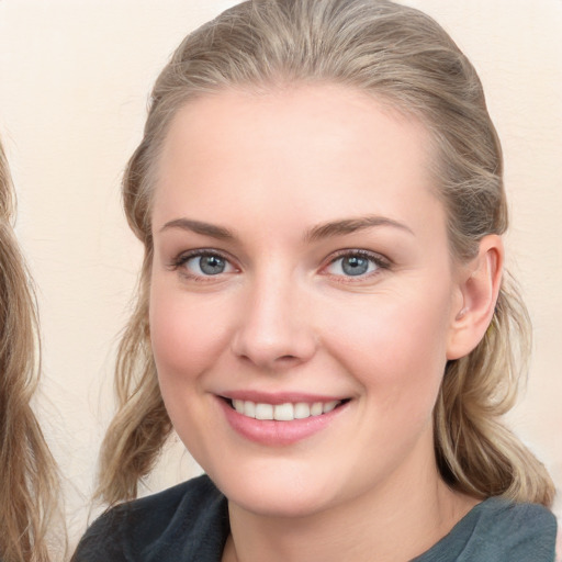 Joyful white young-adult female with long  brown hair and blue eyes