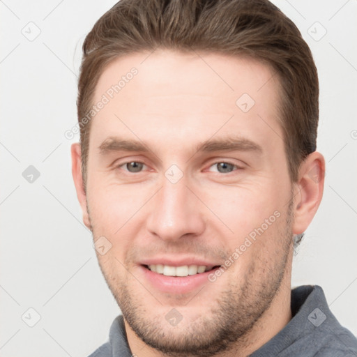 Joyful white young-adult male with short  brown hair and grey eyes