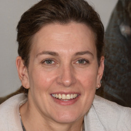 Joyful white adult female with medium  brown hair and grey eyes