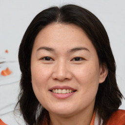 Joyful asian adult female with medium  brown hair and brown eyes