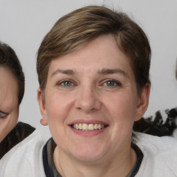 Joyful white adult female with medium  brown hair and blue eyes