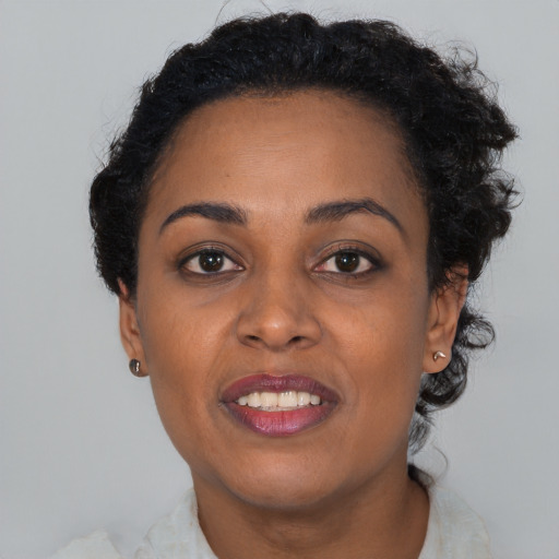 Joyful black young-adult female with short  brown hair and brown eyes