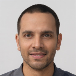 Joyful white young-adult male with short  black hair and brown eyes