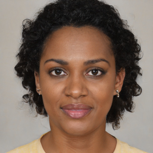 Joyful black young-adult female with medium  brown hair and brown eyes