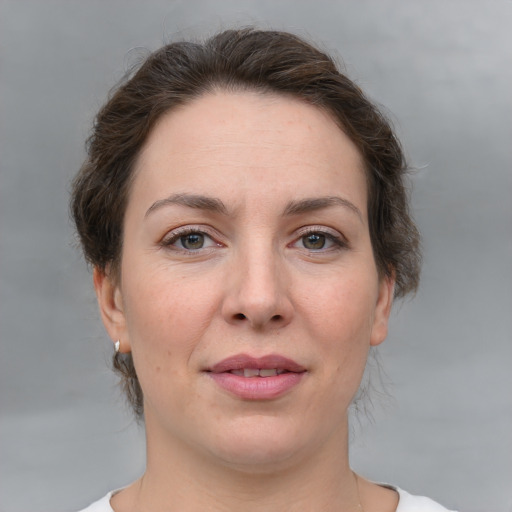 Joyful white adult female with medium  brown hair and grey eyes