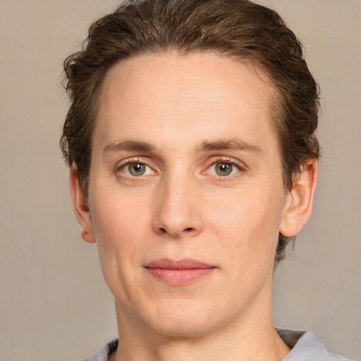 Joyful white young-adult male with short  brown hair and green eyes