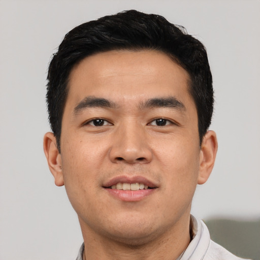 Joyful asian young-adult male with short  black hair and brown eyes