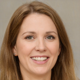 Joyful white young-adult female with long  brown hair and green eyes