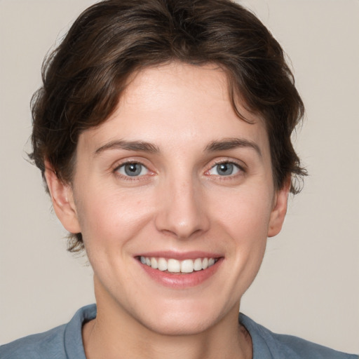 Joyful white young-adult female with short  brown hair and grey eyes