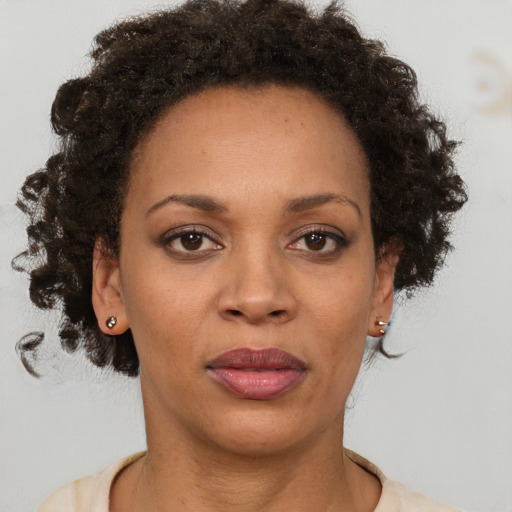 Joyful black adult female with short  brown hair and brown eyes