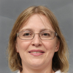 Joyful white adult female with medium  brown hair and blue eyes