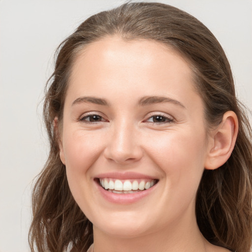 Joyful white young-adult female with long  brown hair and grey eyes