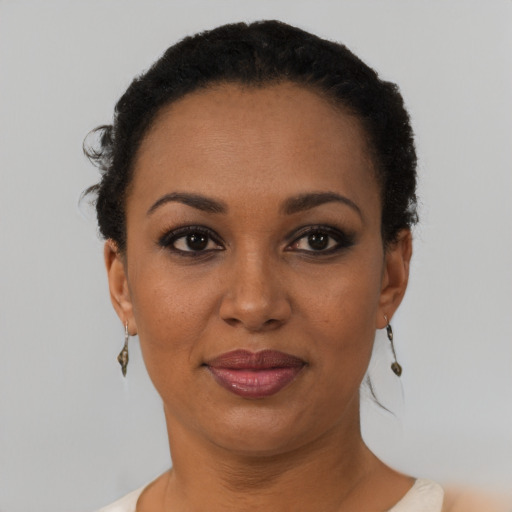 Joyful black adult female with short  black hair and brown eyes