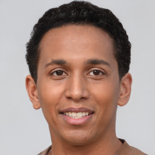Joyful white young-adult male with short  black hair and brown eyes