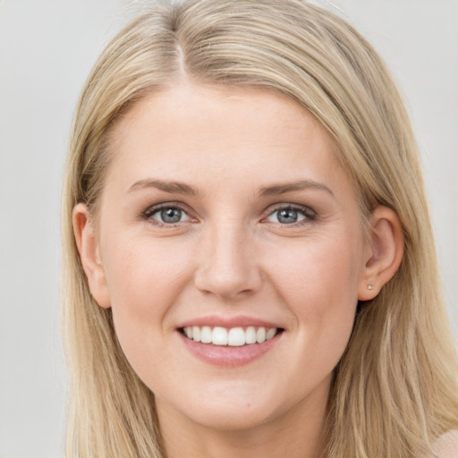 Joyful white young-adult female with long  brown hair and blue eyes