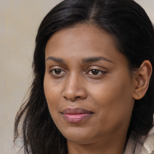Joyful black young-adult female with long  brown hair and brown eyes