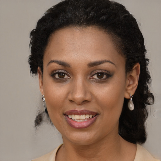 Joyful black young-adult female with long  brown hair and brown eyes