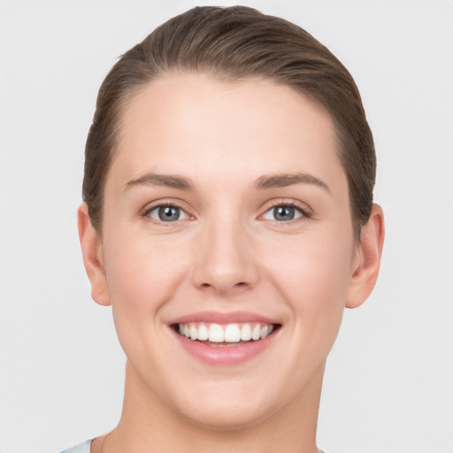 Joyful white young-adult female with short  brown hair and grey eyes