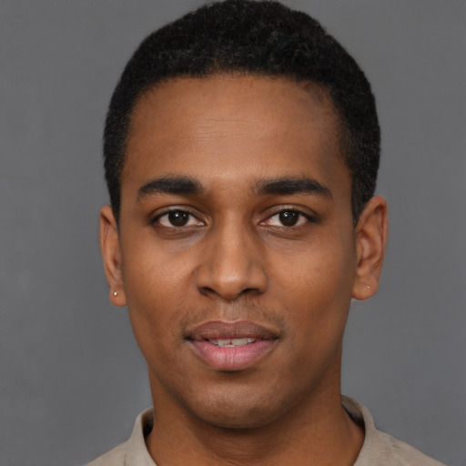 Joyful black young-adult male with short  black hair and brown eyes