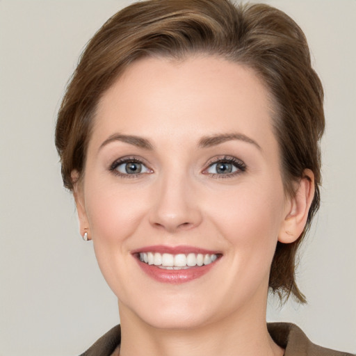 Joyful white young-adult female with medium  brown hair and grey eyes