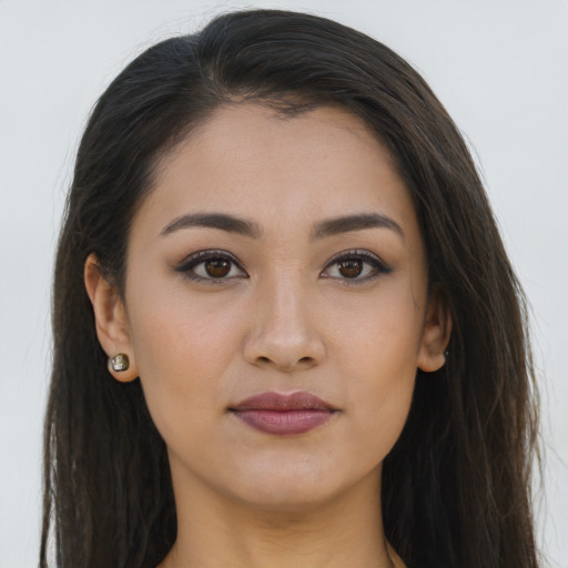 Joyful latino young-adult female with long  brown hair and brown eyes