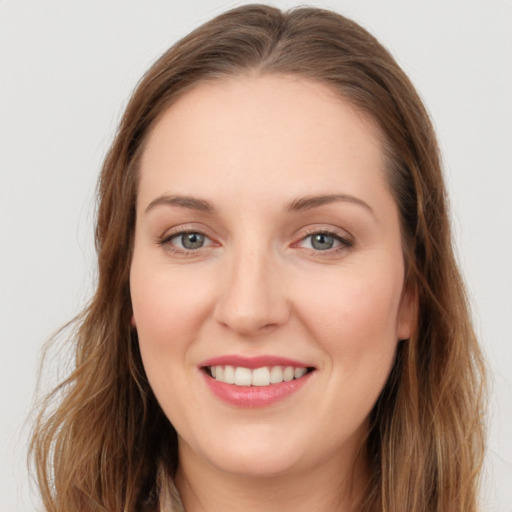 Joyful white young-adult female with long  brown hair and grey eyes