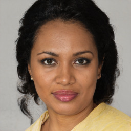 Joyful black adult female with medium  brown hair and brown eyes