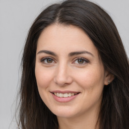 Joyful white young-adult female with long  brown hair and brown eyes