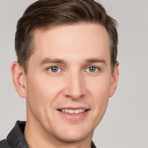 Joyful white young-adult male with short  brown hair and grey eyes