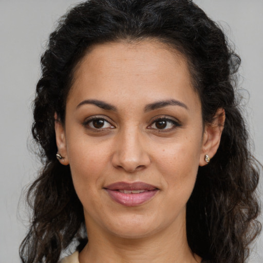 Joyful latino adult female with long  brown hair and brown eyes