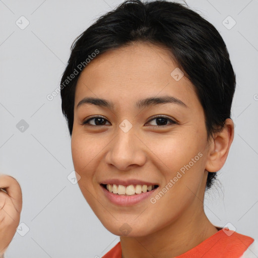 Joyful latino young-adult female with short  brown hair and brown eyes