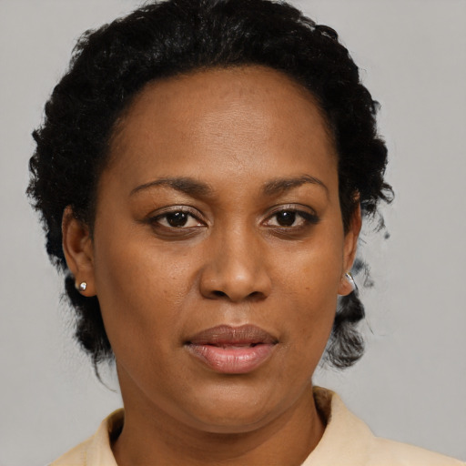 Joyful black adult female with short  black hair and brown eyes