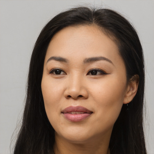 Joyful asian young-adult female with long  brown hair and brown eyes