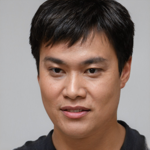 Joyful asian young-adult male with short  brown hair and brown eyes