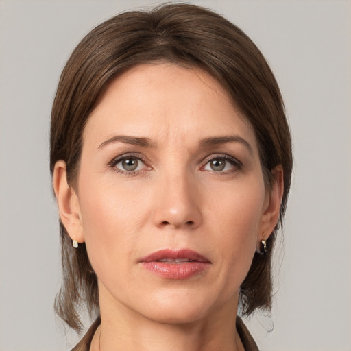 Joyful white young-adult female with medium  brown hair and grey eyes