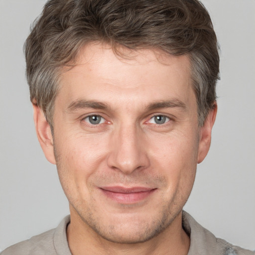 Joyful white adult male with short  brown hair and grey eyes