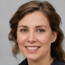 Joyful white adult female with medium  brown hair and brown eyes