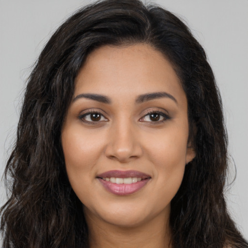 Joyful latino young-adult female with long  brown hair and brown eyes
