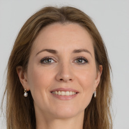 Joyful white young-adult female with long  brown hair and grey eyes