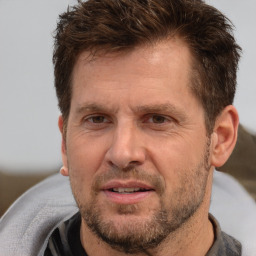 Joyful white adult male with short  brown hair and brown eyes