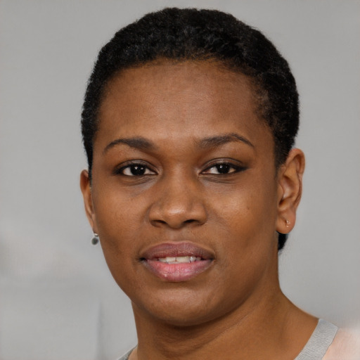 Joyful black young-adult female with short  black hair and brown eyes