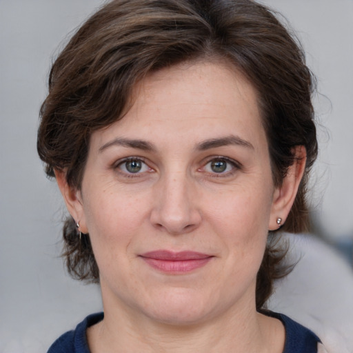 Joyful white adult female with medium  brown hair and grey eyes