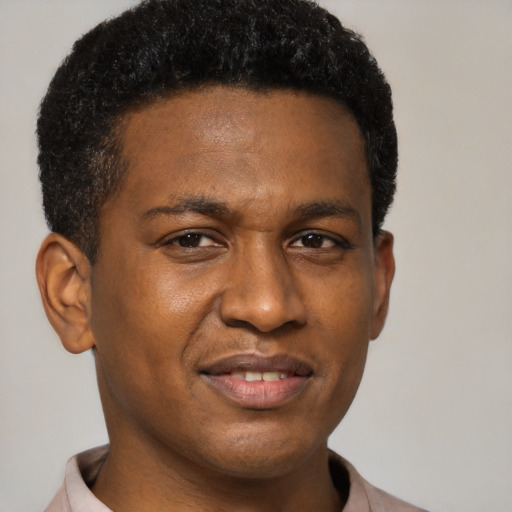 Joyful black young-adult male with short  brown hair and brown eyes