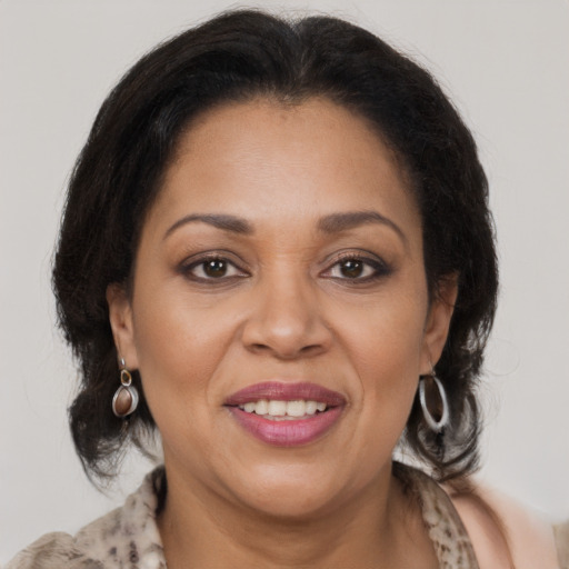 Joyful latino adult female with medium  brown hair and brown eyes