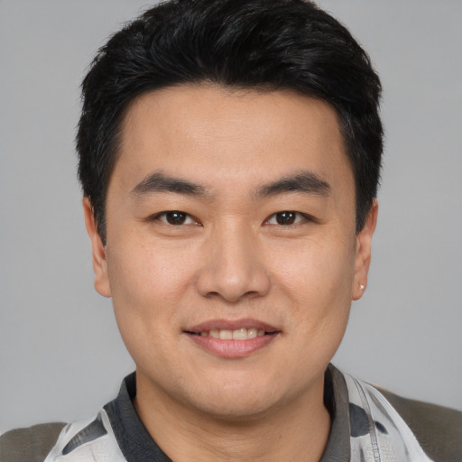 Joyful asian young-adult male with short  black hair and brown eyes