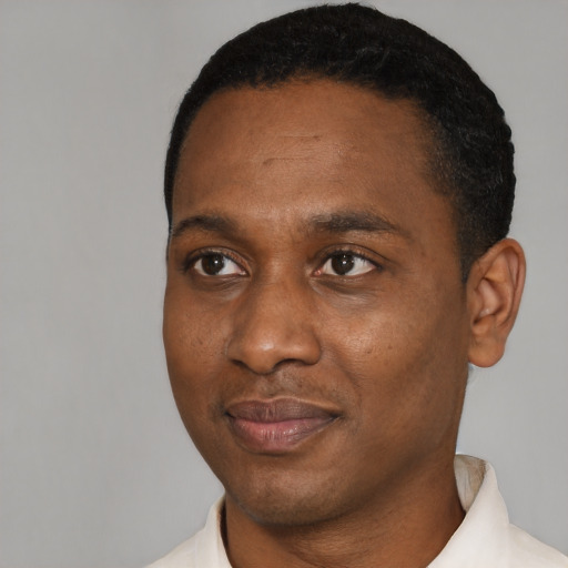 Joyful black young-adult male with short  black hair and brown eyes