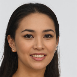 Joyful latino young-adult female with long  brown hair and brown eyes