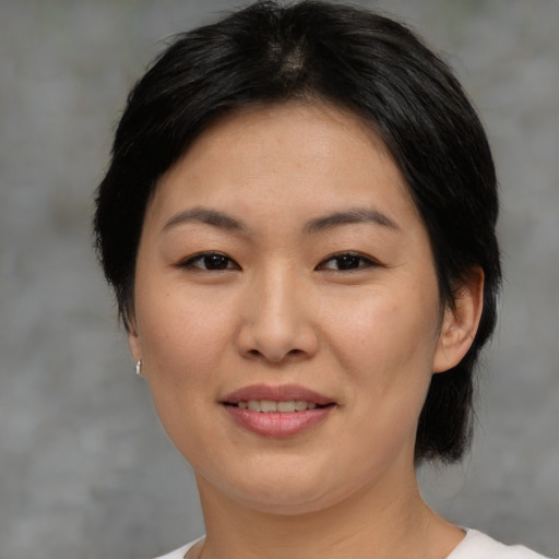 Joyful asian young-adult female with medium  black hair and brown eyes